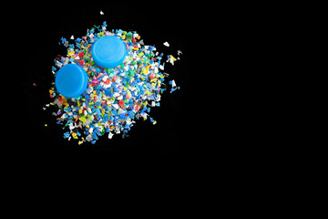 Crushed plastic granules for recycling,  Crushed plastic granules isolated on black background. Plastic crusher. Recycled plastic with mixed colors. The concept of recycled plastic used.