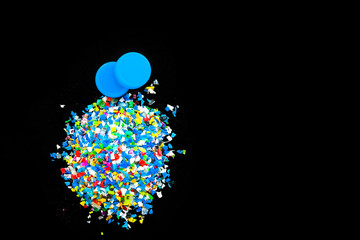 Crushed plastic granules for recycling,  Crushed plastic granules isolated on black background....