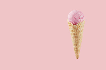 Strawberry ice cream in crisp waffle cone on pastel pink background, mock up for design, summer food.