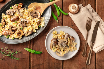 Mushroom and cheese pasta. Farfalle with cremini and green peas, shot from above with ingredients on a dark rustic wooden background