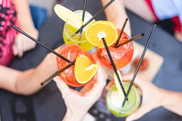Plexiglas foto achterwand Alcoholische drankglazen die elkaar raken voor het roosteren van een feest. Close-up shot zonder herkenbare mensen © Lomb