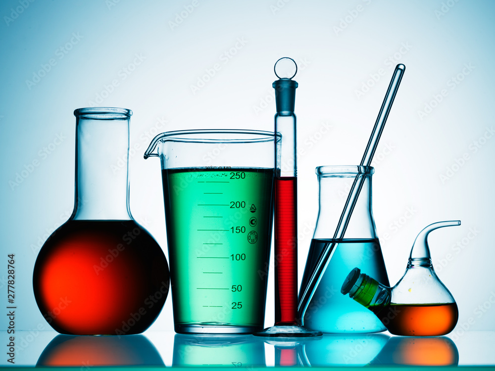 Wall mural different laboratory glassware with color liquid and with reflection