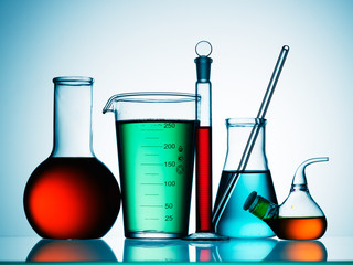 Different laboratory glassware with color liquid and with reflection
