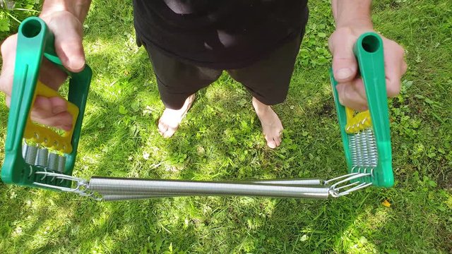 A man does exercises with an expander. Training with an expander.