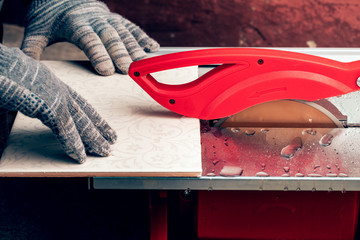 Cutting floor tiles using tile cutter machine, Cutting ceramic tiles with electric machine.