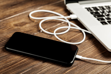 A USB cable connects your phone and laptop