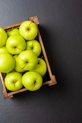 Overhead shot of green apples on black table