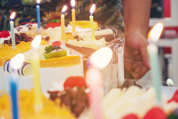 Fresh milk cakes and beautifully decorated fruits with birthday candles prepared to surprise.