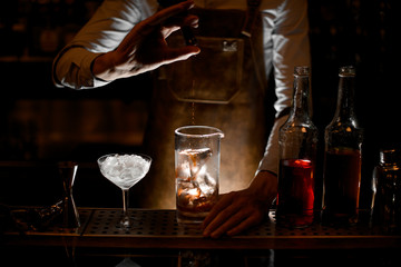 Bartender pouring an essence from the little glass bottle