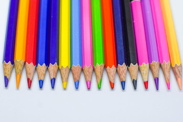 Multiple colored pencils on a white background