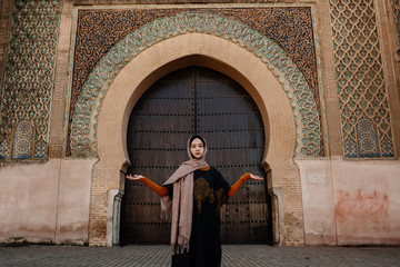 Tourist by authentic gate in Meknes, Morocco