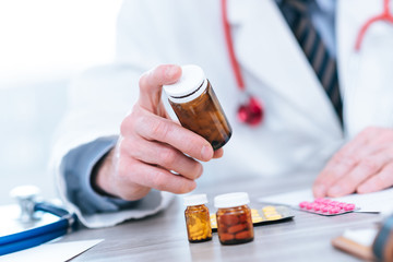 Doctor looking at a bottle of pills