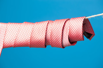 Corbata con su nudo hecho y colgada de una cuerda y sujeta por pinzas de madera de extender la ropa