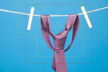 Corbata, nudo de corbata, corbata sobre fondo liso, corbata en una cuerda y sujeta por pinzas de extender la ropa