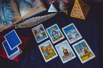 Fototapeta na wymiar Mystical atmosphere of tarot card on the table, esoteric concept, fortune telling and predictions 