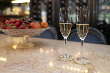 Two glasses filled with champagne at the restaurant. A romantic evening.