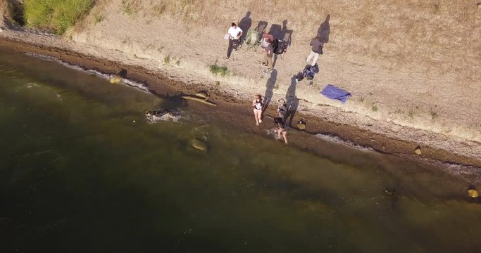 aerial drone high angle shot of familly having fun on the Lake Chacuma, relaxing and playing fetch game with their dog german shepherd