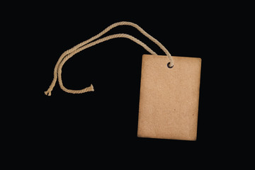 blank paper price tag or label on a beautiful twisted cord, isolated on a black background