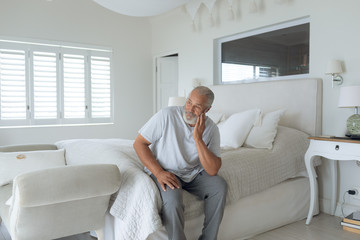 Man sitting on the bed inside white room