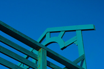 Arch at the entrance to the pier and railing of blue against the sky