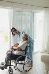 Fototapeta premium Healthcare worker talking with man on wheelchair