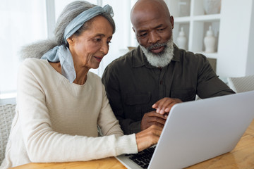 Couple using white laptop on a table.