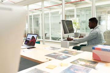 Male graphic designer using graphic tablet at desk