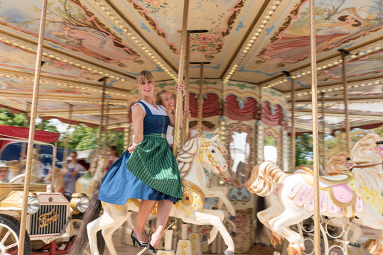 Wundersch&ouml;ne Frau in Tracht f&auml;hrt Karussell auf der Dult