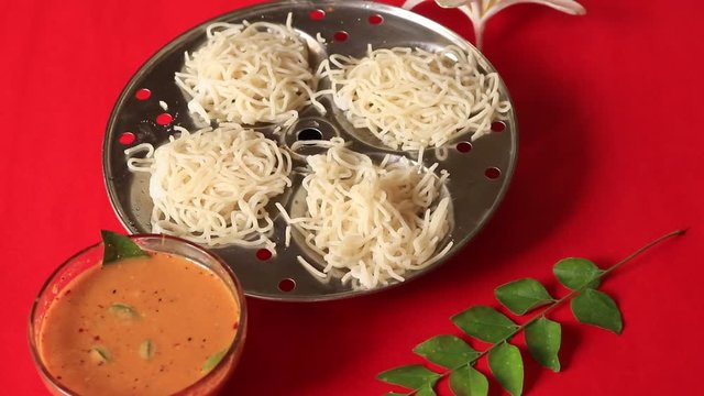 Idiyappam/ String Hoppers -Traditional Kerala Steamed Breakfast on red background