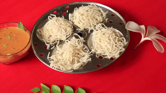 Idiyappam/ String Hoppers -Traditional Kerala Steamed Breakfast on red background