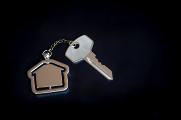 House key with home keyring in on black background