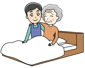 ベッドに寝ている老人女性をサポートする介護士の男性