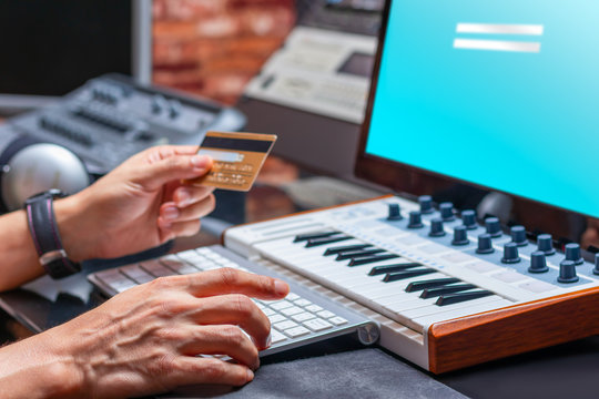 musician hands holding credit card for online shopping in music studio
