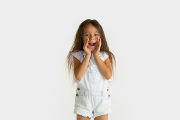 Beautiful female half-length portrait isolated on white studio background. Little emotional asian girl wearing white. Facial expression, human emotions, advertising, sales concept. Screaming happy.