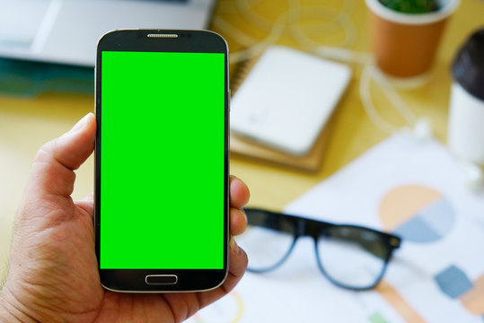 Businessman using mobile smartphone with green screen display