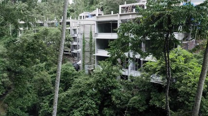 Aerial: illegal construction of hotels amongst a tropical rainforest. Ubud, Bali, Indonesia. 2 March 2019