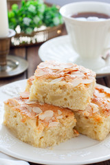 Homemade Apple Pie with Almond Petals on White Crockery, selective focus