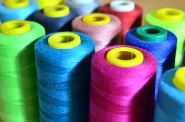 Background of bobbins with multicolored threads for sewing. Needlework, sewing and tailoring...