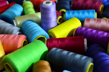 Background of bobbins with multicolored threads for sewing. Needlework, sewing and tailoring...