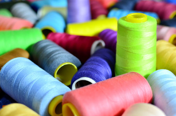 Background of bobbins with multicolored threads for sewing. Needlework, sewing and tailoring...