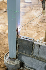 Worker welding the steel rod in core of wall center before brick the  wall