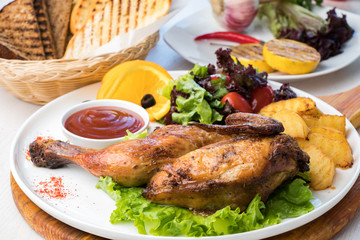 Fried chicken with potatoes and fresh salad on a white plate