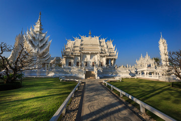 Fototapeta na wymiar Weisser Tempel Wat Rong Khun in Chiang Rai, in der Abendsonne mit Schatten, Thailand