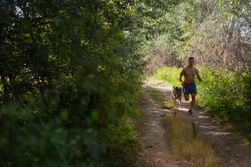 runner running across the field with his dog