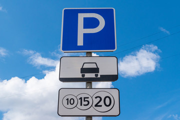 Road sign parking against the blue sky. A sign of a paid parking. Close-up.