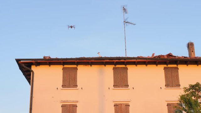 drone flying close to damaged roof house checking storm damage
