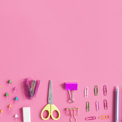 Various stationeries at the bottom of pink background
