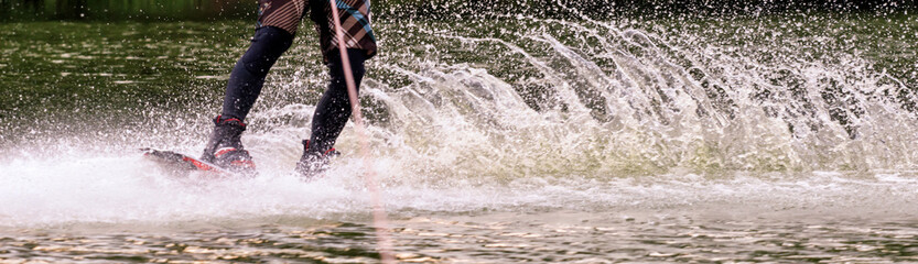 Fototapeta premium male athlete rides on a wakeboard on lake in summer