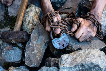 The hands of a slave in an attempt to release. The symbol of slave labor. Hands in chains
