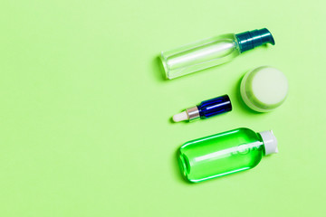 Cosmetics SPA branding mock-up, top view with copy space. set of tubes and jars of cream flat lay on gren background